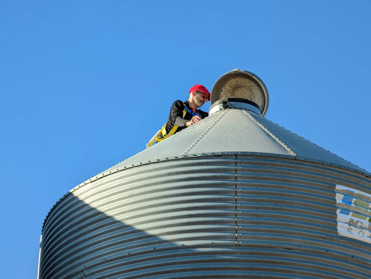 Un opérateur examine l'ouverture au sommet d'un silo à grain