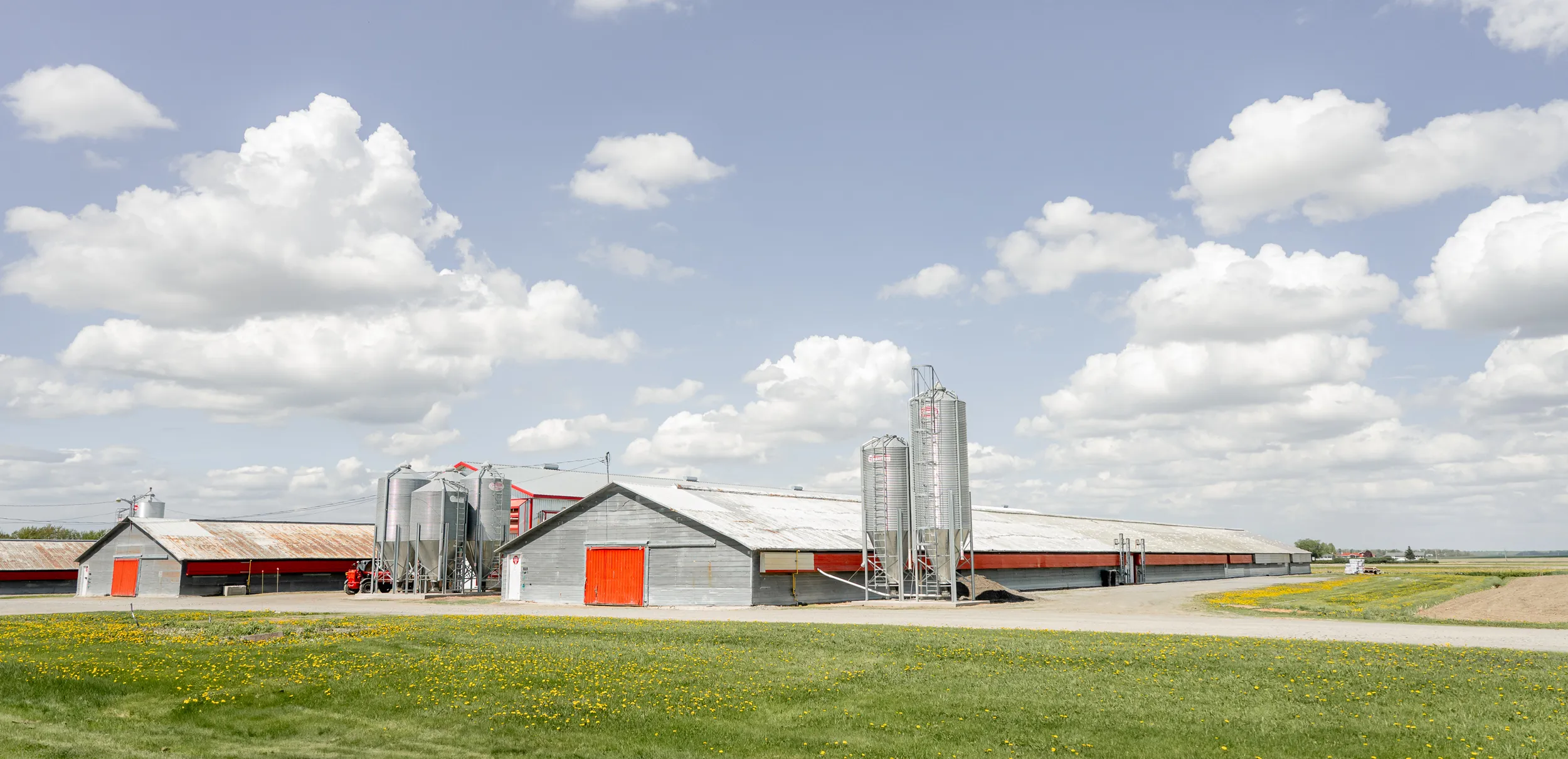 Toitures de bâtiments agricoles et silos sous un ciel nuageux